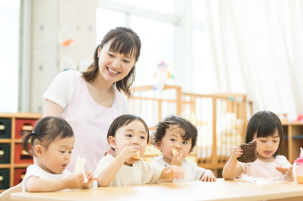 保育園でおやつを食べる子どもたち